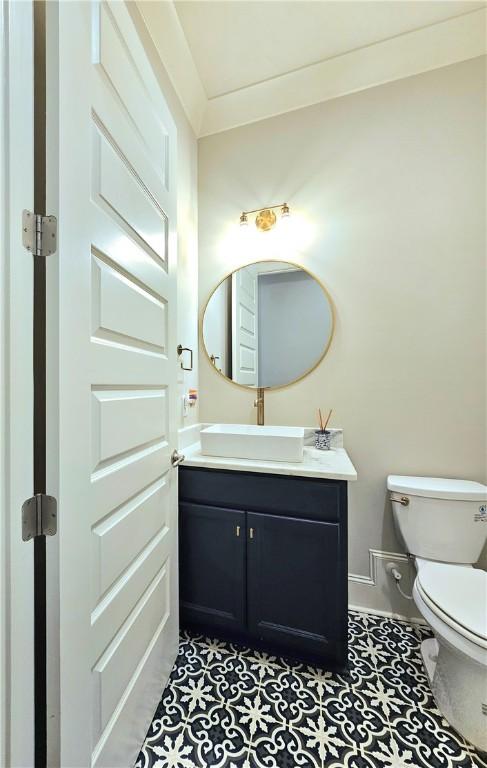 bathroom with vanity, toilet, and ornamental molding