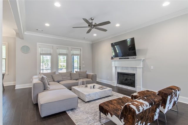 living room with ceiling fan, crown molding, a fireplace, and dark wood-type flooring