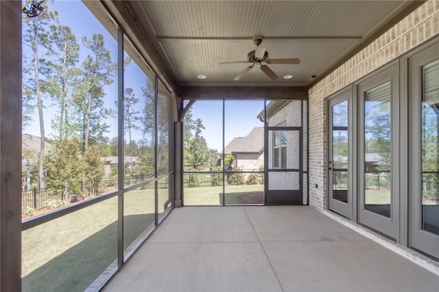 unfurnished sunroom with ceiling fan