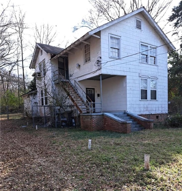 rear view of property featuring stairs