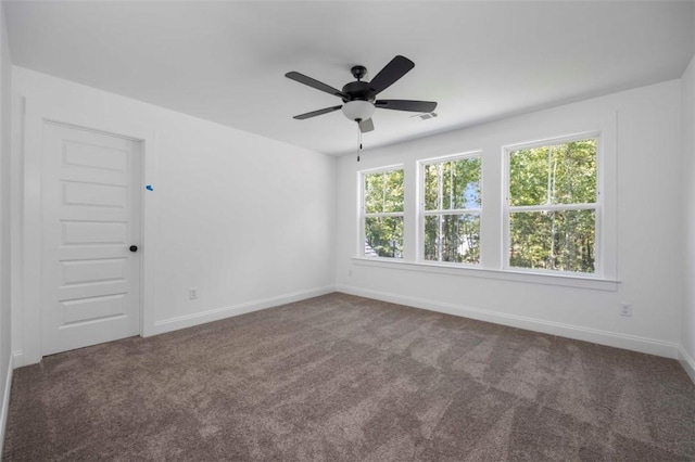 carpeted spare room featuring ceiling fan and a wealth of natural light