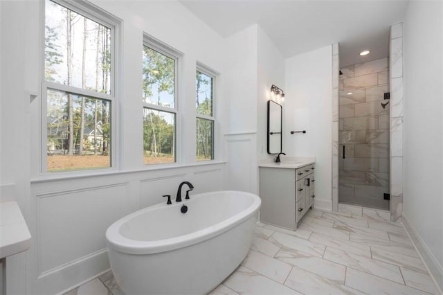 bathroom with a wealth of natural light, vanity, and separate shower and tub