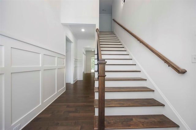 stairs with wood-type flooring and ornamental molding