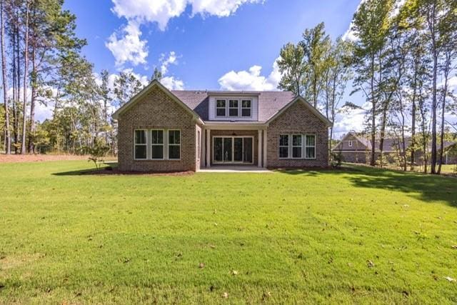 rear view of property featuring a lawn