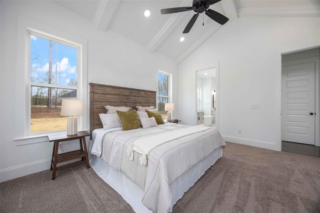 bedroom with ceiling fan, dark colored carpet, vaulted ceiling with beams, and ensuite bathroom