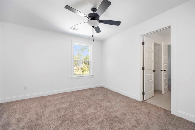 spare room with ceiling fan and light carpet