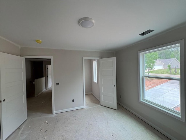 unfurnished bedroom with baseboards and multiple windows