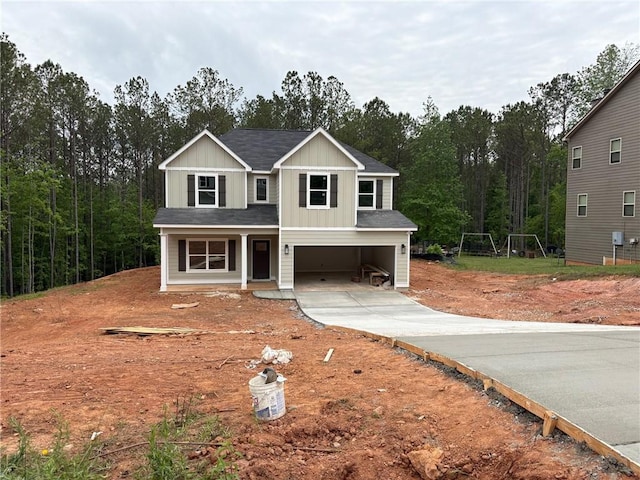view of front of home featuring covered porch, driveway, board and batten siding, roof with shingles, and an attached garage