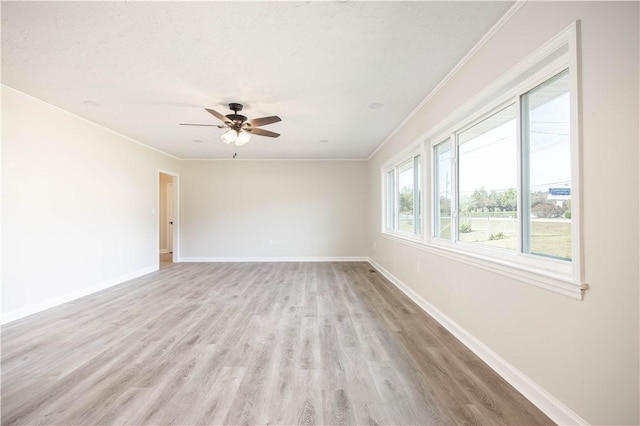 spare room with a textured ceiling, ceiling fan, light wood-type flooring, and crown molding