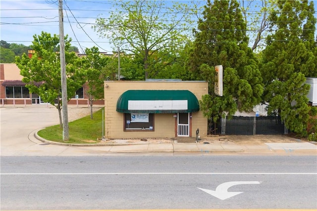 view of front of house featuring fence and concrete block siding