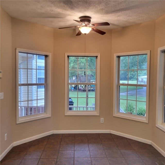 tiled spare room with ceiling fan and a textured ceiling