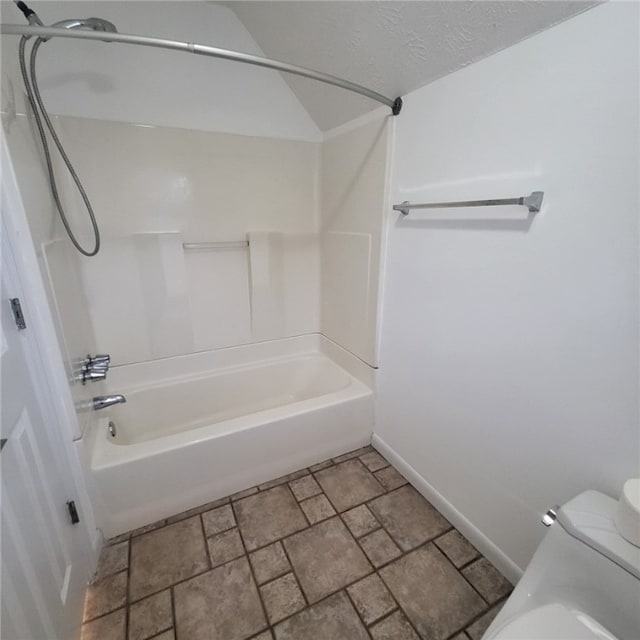 bathroom featuring  shower combination, toilet, and a textured ceiling