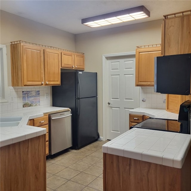 kitchen featuring kitchen peninsula, light tile patterned floors, tasteful backsplash, and stainless steel dishwasher