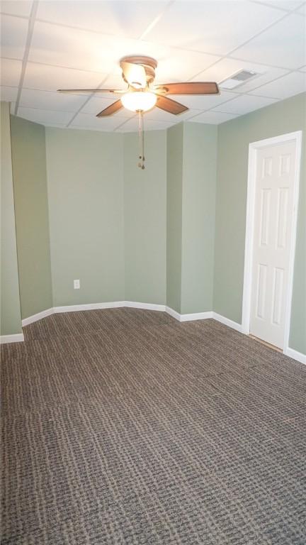 carpeted spare room with a paneled ceiling and ceiling fan