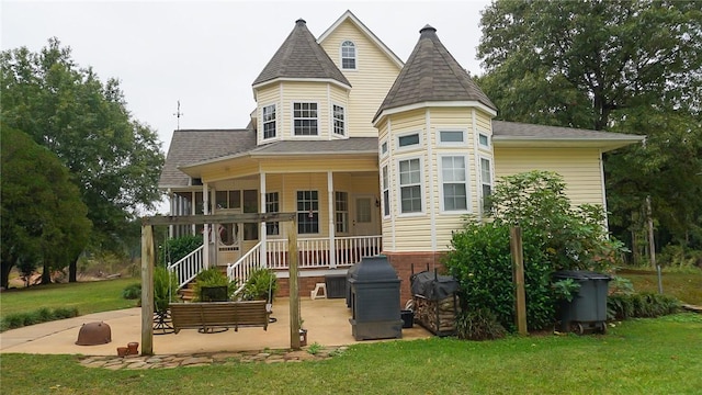 back of property with a patio and a lawn