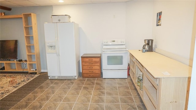 kitchen featuring a drop ceiling and white appliances