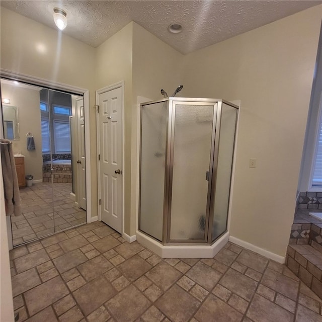 bathroom with shower with separate bathtub and a textured ceiling