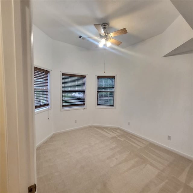 carpeted empty room with ceiling fan and vaulted ceiling