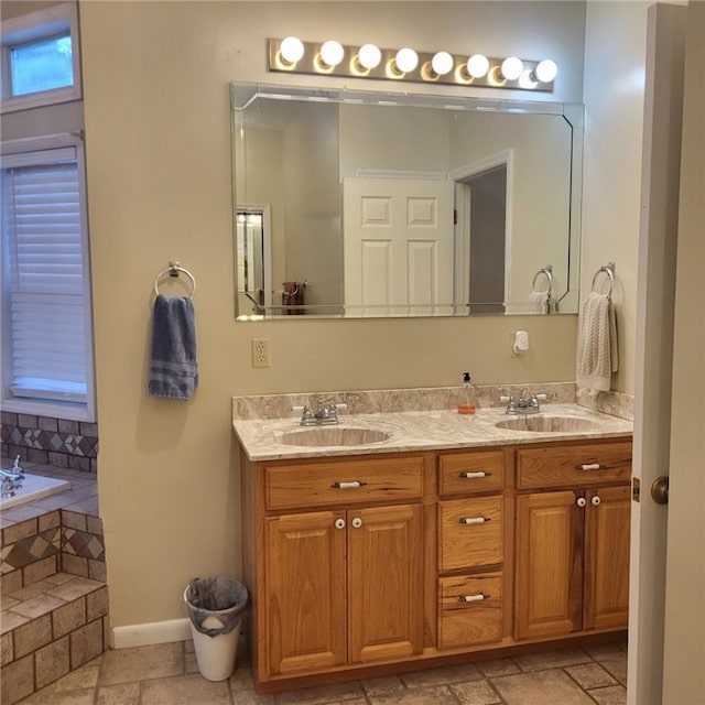 bathroom featuring tiled tub and vanity