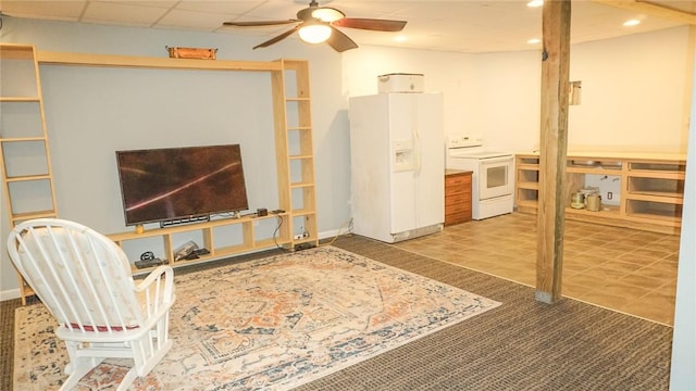 living room featuring ceiling fan and a drop ceiling