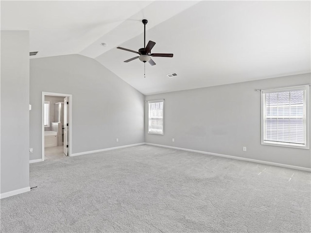 empty room featuring baseboards, visible vents, lofted ceiling, ceiling fan, and light carpet