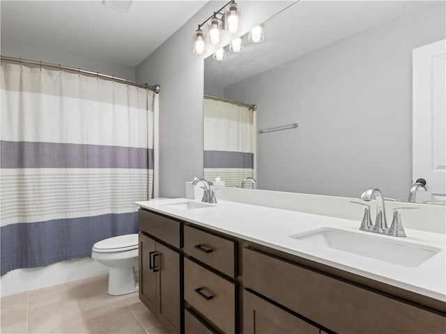 full bathroom featuring double vanity, toilet, tile patterned floors, and a sink