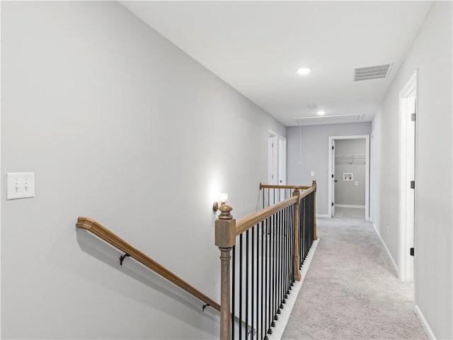 hall featuring visible vents, carpet floors, baseboards, attic access, and an upstairs landing