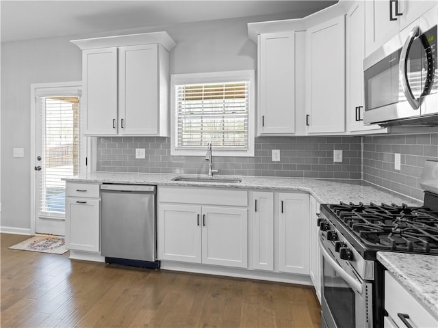 kitchen featuring dark wood finished floors, appliances with stainless steel finishes, white cabinetry, and a sink