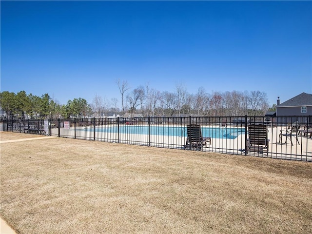 pool featuring a patio area, fence, and a lawn