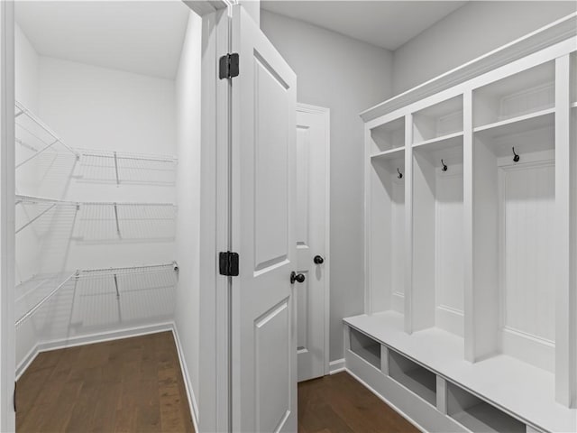 mudroom with dark wood finished floors and baseboards