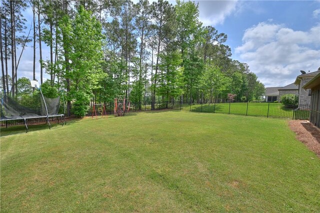 view of yard featuring a fenced backyard and a trampoline