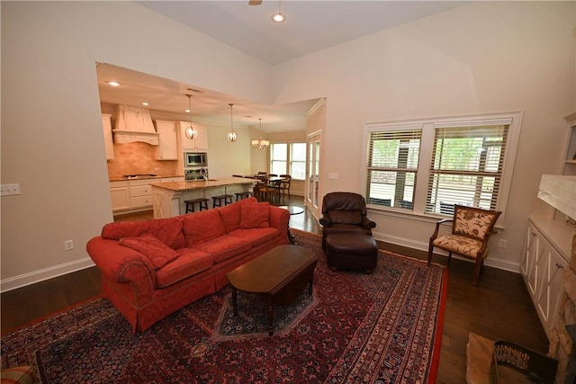 living area featuring recessed lighting, dark wood-style flooring, and baseboards
