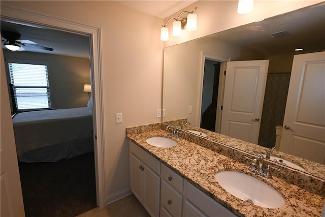 ensuite bathroom featuring double vanity, a sink, and ceiling fan