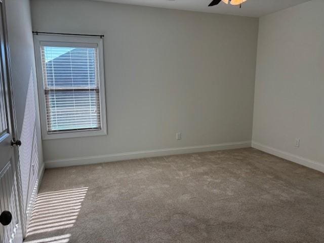 spare room with ceiling fan and light colored carpet