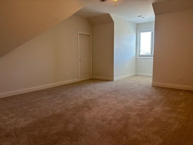 additional living space featuring ceiling fan, vaulted ceiling, and carpet floors