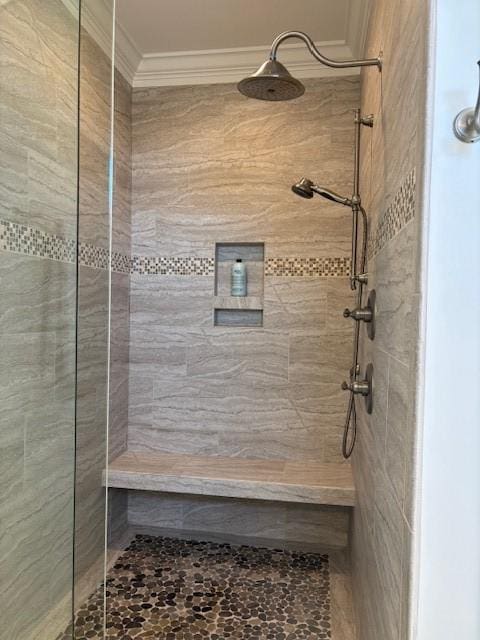 bathroom with a tile shower and crown molding