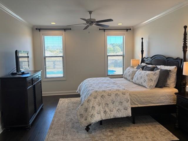 bedroom featuring ceiling fan, dark wood-type flooring, and crown molding