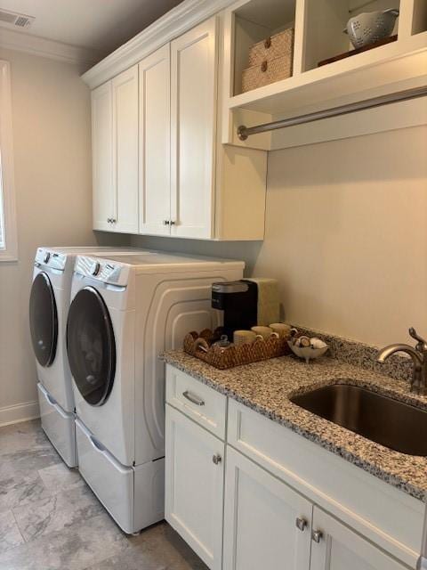 laundry area featuring washer and dryer, cabinets, and sink