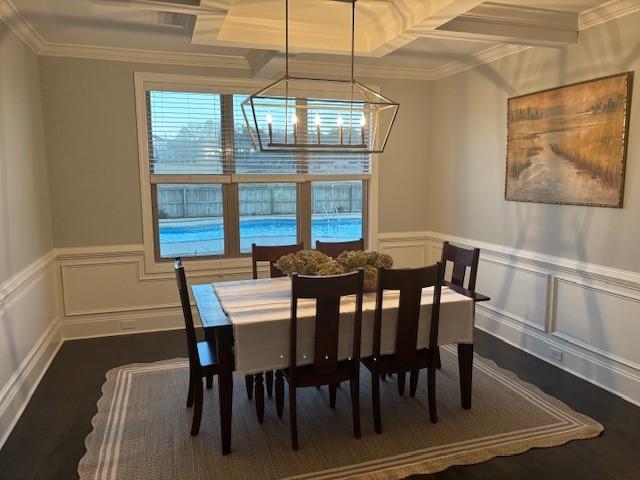 dining space with ornamental molding, a notable chandelier, coffered ceiling, and beamed ceiling