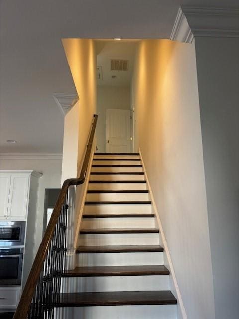 stairs featuring crown molding