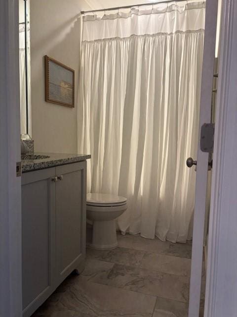 bathroom with toilet, vanity, and a shower with curtain