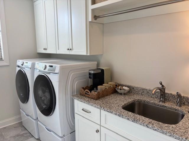 washroom featuring sink, washer and clothes dryer, and cabinets