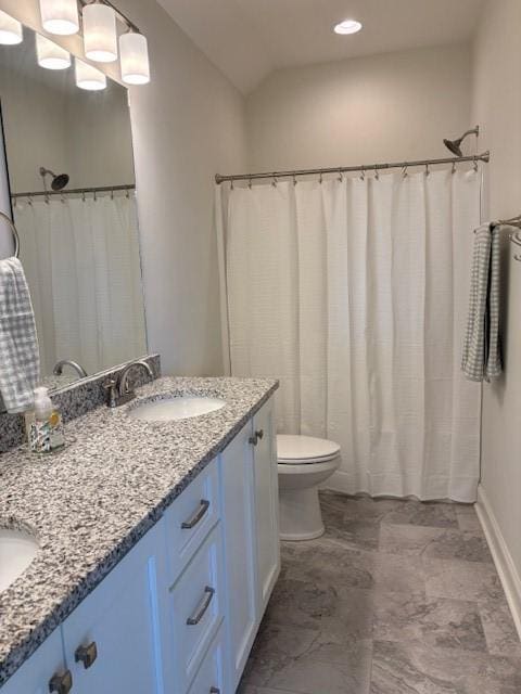 bathroom featuring lofted ceiling, vanity, and toilet