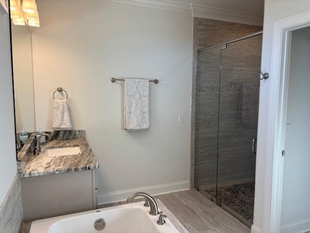 bathroom with ornamental molding, vanity, and shower with separate bathtub