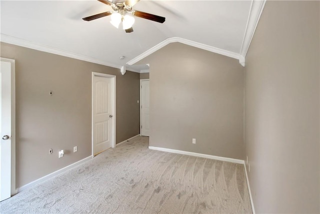 carpeted empty room featuring baseboards, ornamental molding, a ceiling fan, and lofted ceiling