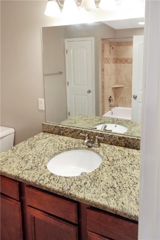 bathroom featuring vanity, bathtub / shower combination, and toilet