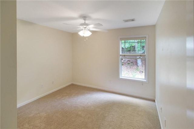 spare room with ceiling fan, visible vents, baseboards, and carpet