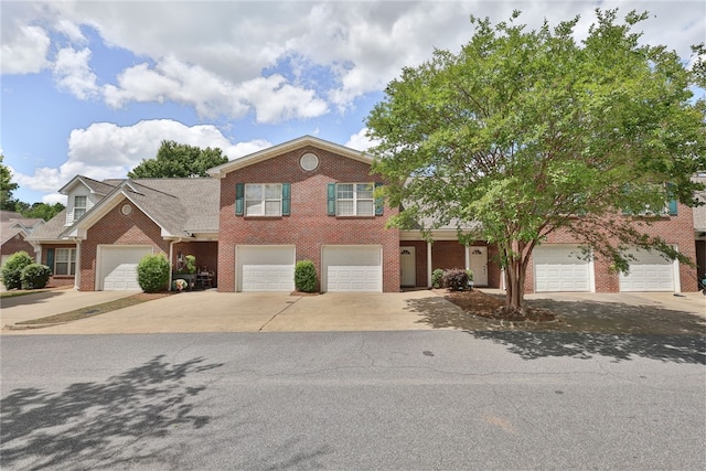 traditional-style home with driveway, brick siding, and a garage