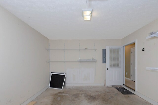 garage with baseboards and electric panel