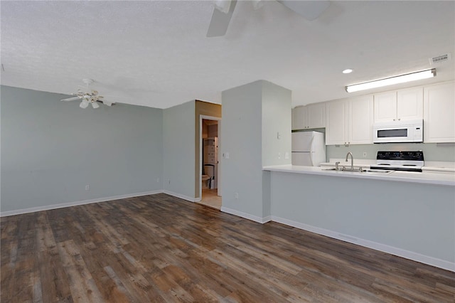 kitchen featuring white appliances, ceiling fan, a sink, light countertops, and recessed lighting